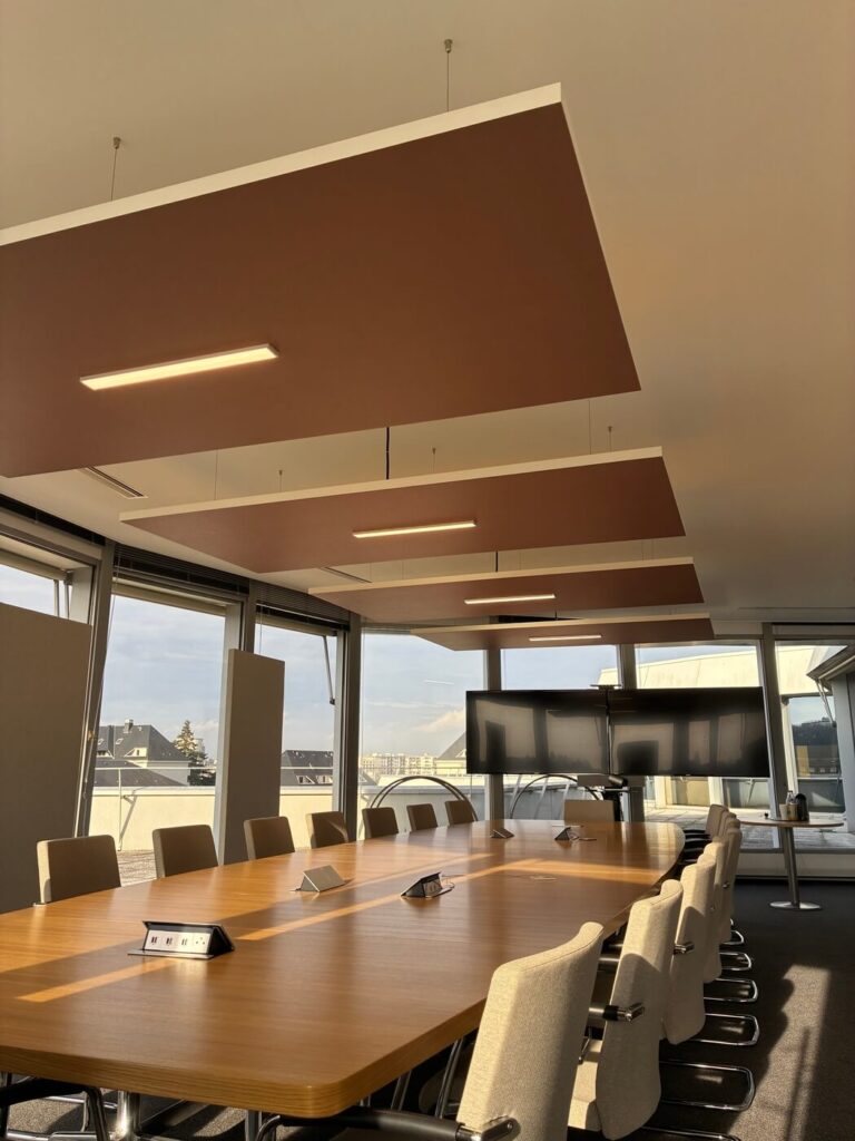 Salle de réunion moderne avec grande table en bois.